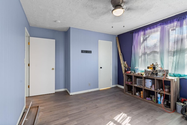 miscellaneous room featuring wood-type flooring and a textured ceiling