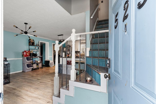 entrance foyer featuring crown molding, wood-type flooring, and a textured ceiling