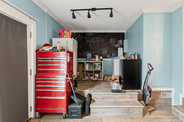 misc room featuring hardwood / wood-style floors, crown molding, and a textured ceiling