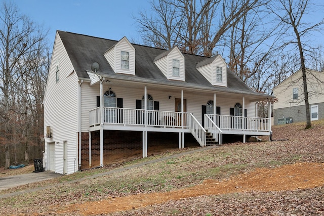 new england style home featuring a garage and covered porch