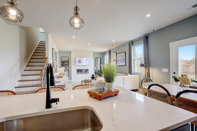 kitchen with pendant lighting, a fireplace, and sink