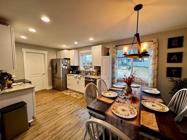 dining space with an inviting chandelier and light wood-type flooring