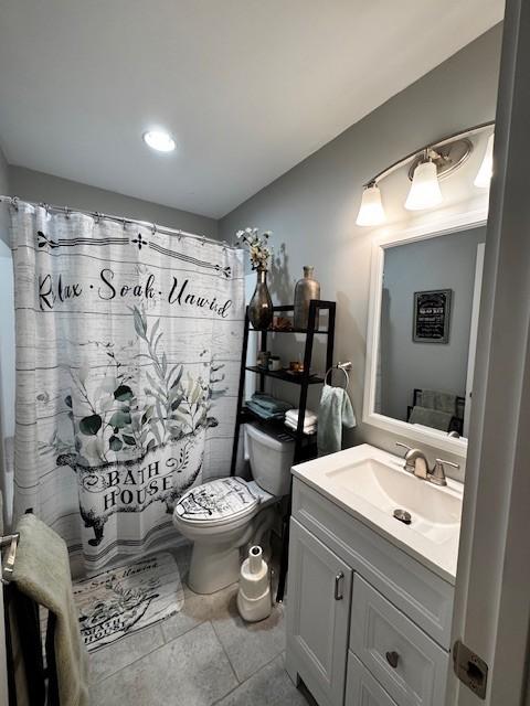 bathroom featuring vanity, a shower with shower curtain, tile patterned floors, and toilet