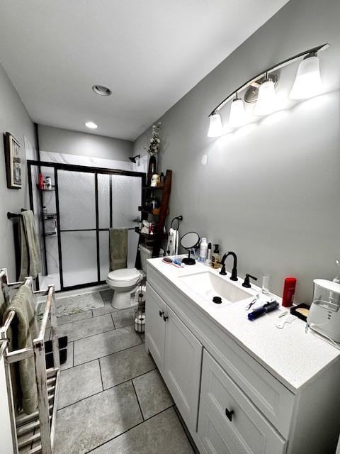 bathroom with tile patterned flooring, vanity, toilet, and walk in shower