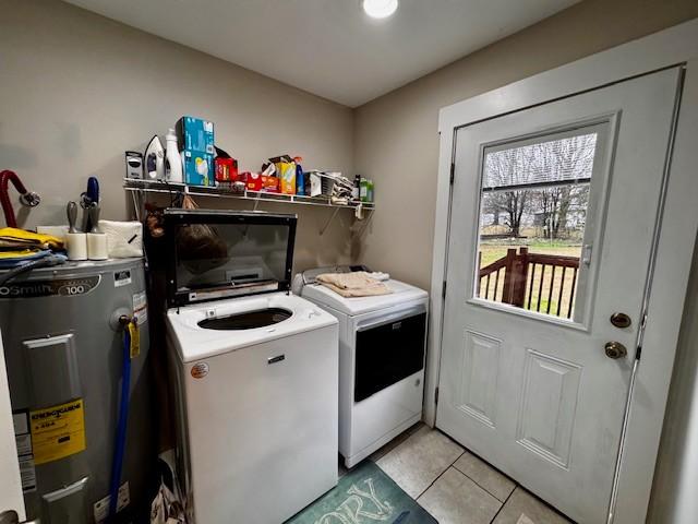 laundry area with separate washer and dryer, water heater, and light tile patterned floors