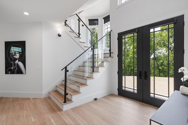 foyer featuring french doors, light hardwood / wood-style floors, and a wealth of natural light