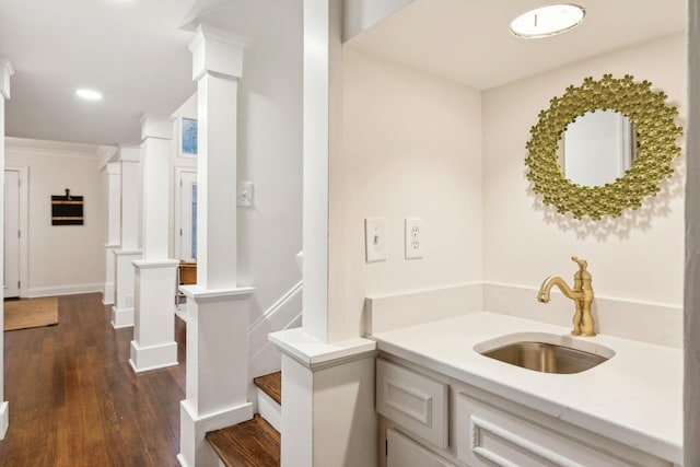 bathroom with crown molding, sink, hardwood / wood-style flooring, and decorative columns