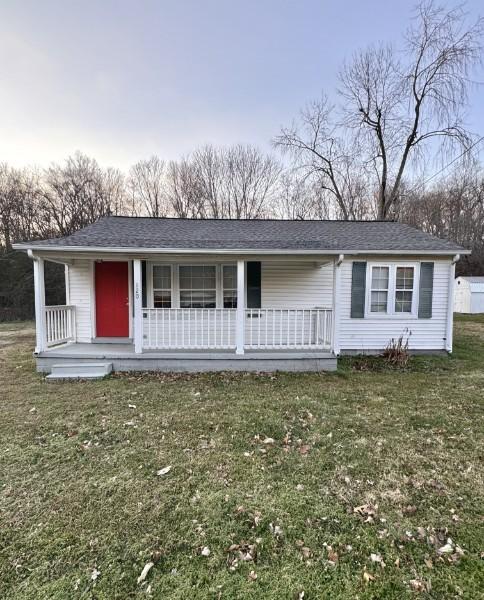 ranch-style house with covered porch and a front lawn