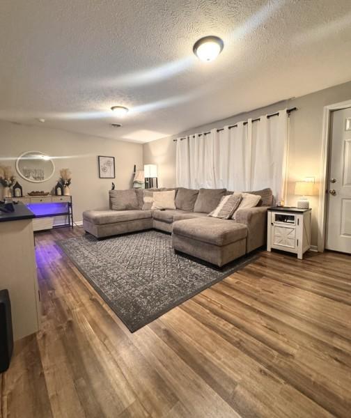 living room with hardwood / wood-style floors and a textured ceiling