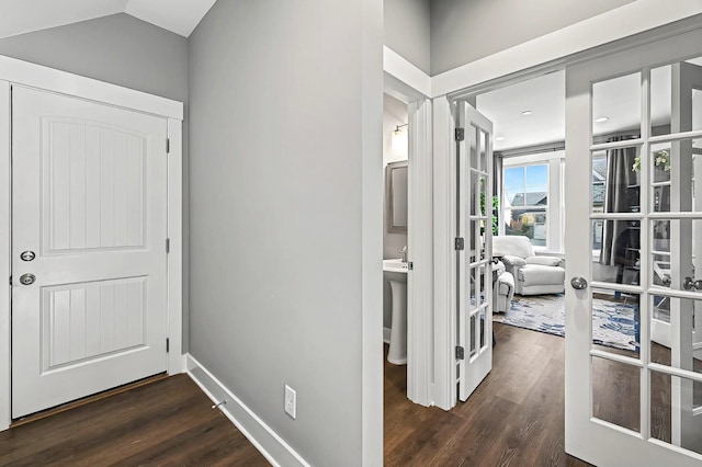 corridor featuring dark wood-type flooring, lofted ceiling, and french doors