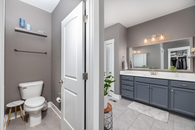 bathroom featuring vanity, tile patterned floors, and toilet