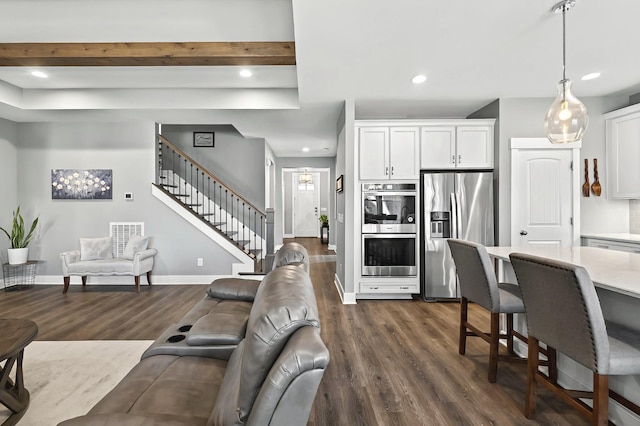 living room featuring beam ceiling and dark hardwood / wood-style floors