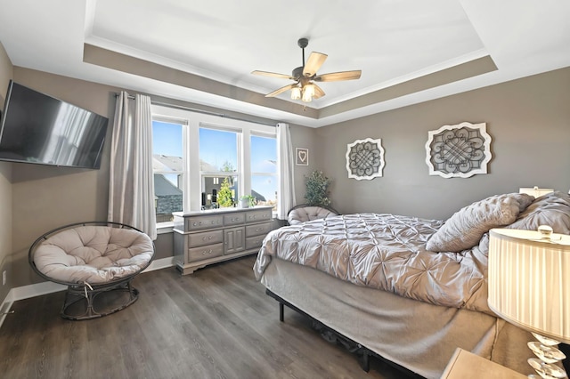 bedroom featuring crown molding, dark wood-type flooring, and a raised ceiling