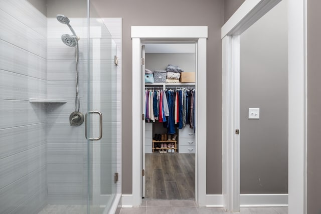 bathroom featuring a shower with shower door and tile patterned floors