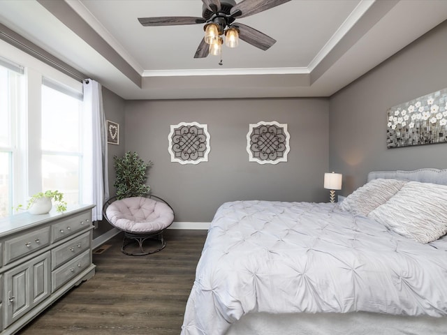 bedroom featuring a raised ceiling, ornamental molding, dark hardwood / wood-style floors, and ceiling fan