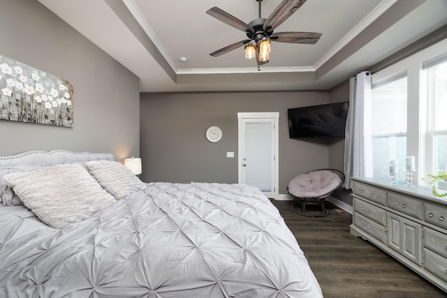 bedroom featuring ceiling fan, ornamental molding, dark hardwood / wood-style floors, and a raised ceiling