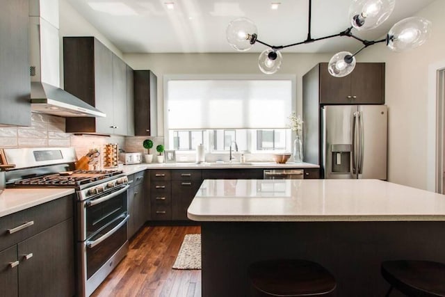 2122 9th Ave N, Nashville, TN 37208 - kitchen with stainless steel appliances, sink, a kitchen island, and wall chimney range hood