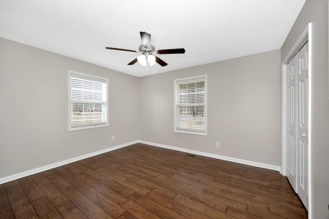 unfurnished room with dark wood-type flooring and ceiling fan