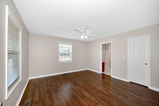 unfurnished bedroom with ceiling fan, dark hardwood / wood-style floors, and a textured ceiling