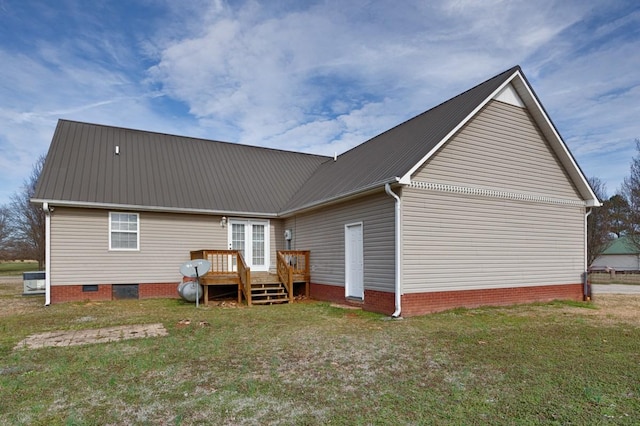 rear view of property featuring a wooden deck and a yard