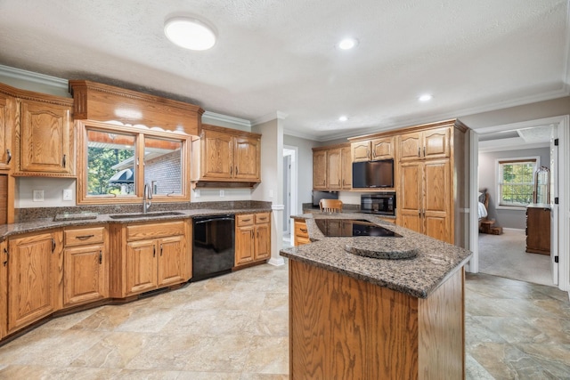 kitchen with sink, a center island, ornamental molding, dark stone counters, and black appliances