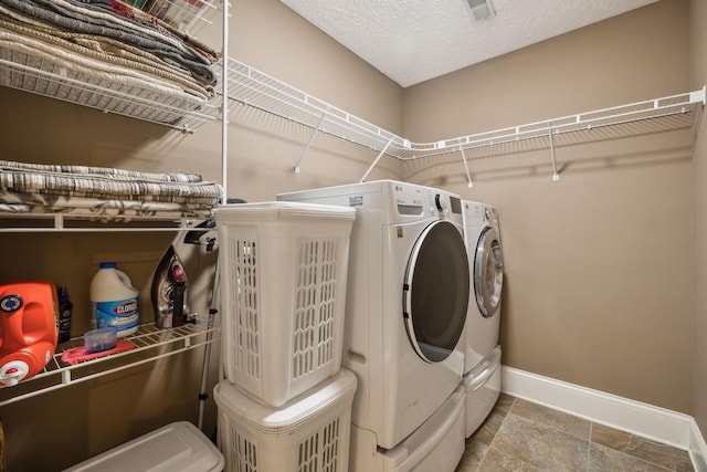 laundry area with separate washer and dryer and a textured ceiling