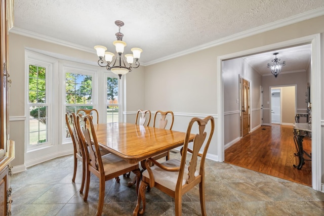 dining area featuring an inviting chandelier, ornamental molding, and a textured ceiling