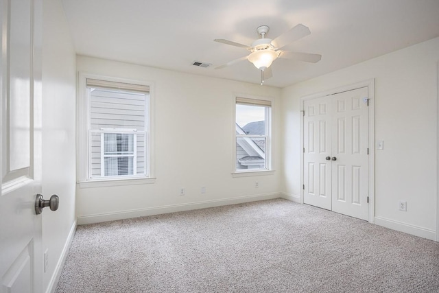 carpeted spare room featuring ceiling fan