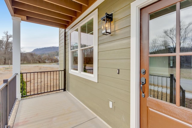 balcony with covered porch and a mountain view