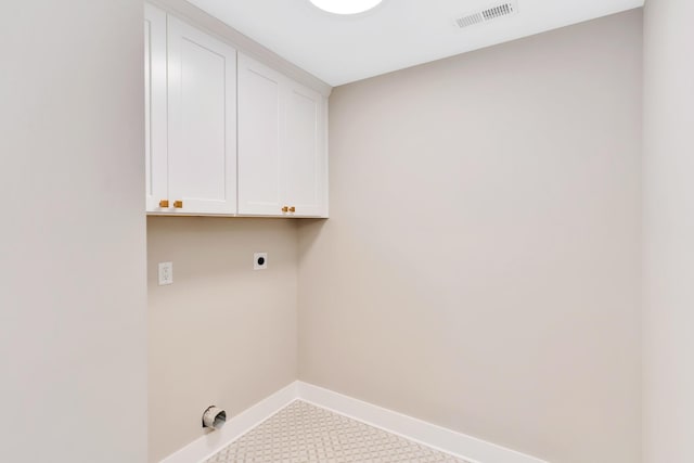 laundry room featuring electric dryer hookup and cabinets