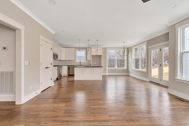 unfurnished living room featuring ornamental molding and dark hardwood / wood-style floors