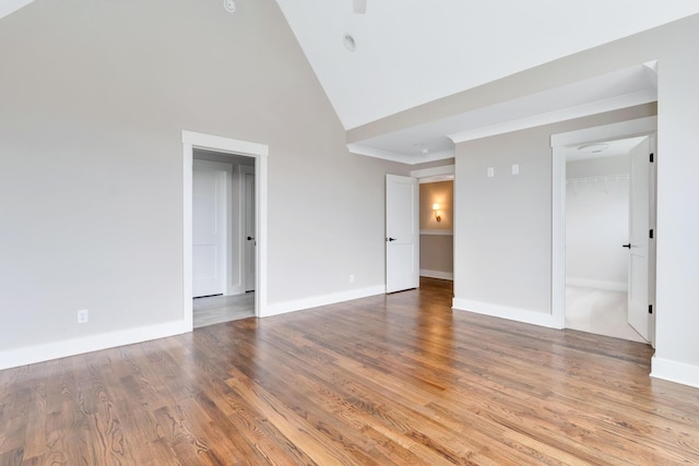 unfurnished room featuring crown molding, hardwood / wood-style floors, and high vaulted ceiling