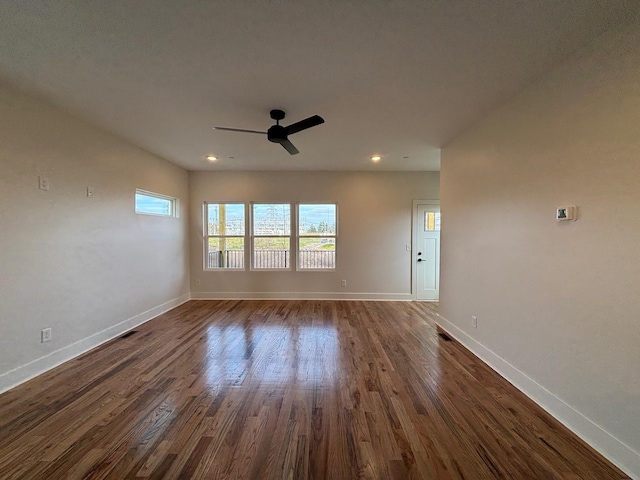 spare room with dark wood-type flooring and ceiling fan