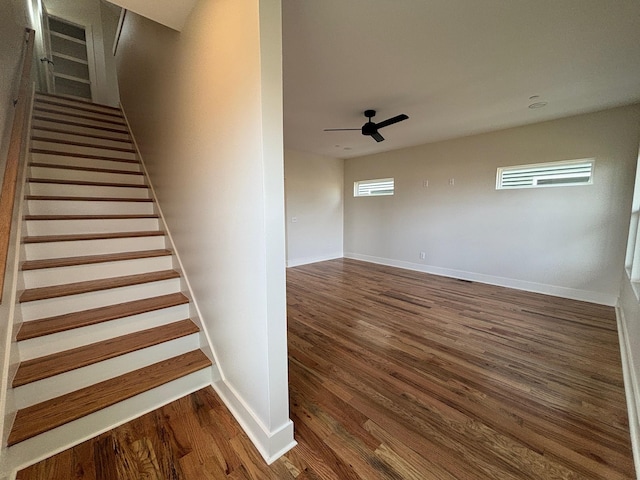 stairs featuring hardwood / wood-style flooring and ceiling fan