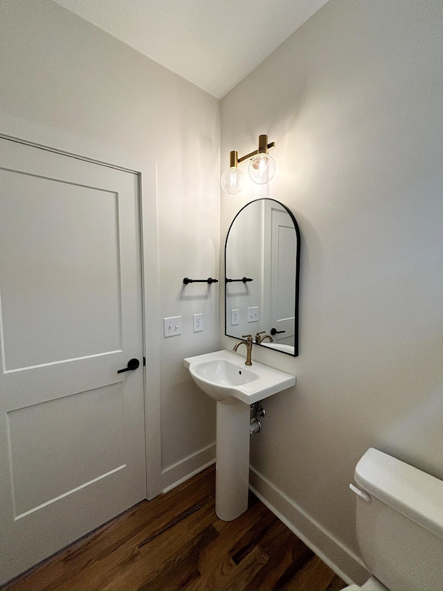 bathroom with hardwood / wood-style flooring and toilet