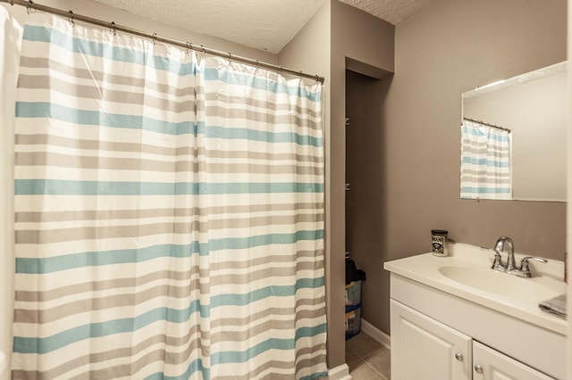 bathroom featuring vanity, tile patterned flooring, and a textured ceiling