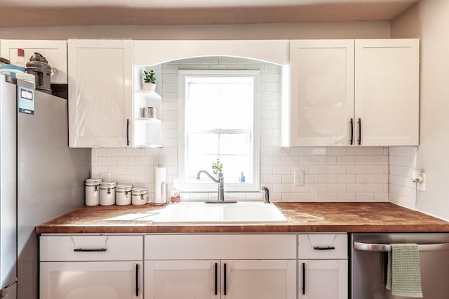 kitchen with stainless steel appliances, white cabinetry, and sink