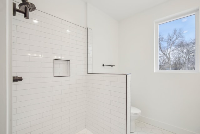 bathroom featuring tile patterned floors, toilet, and tiled shower