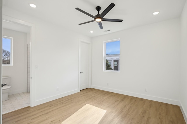 unfurnished bedroom featuring ceiling fan, connected bathroom, and light hardwood / wood-style floors