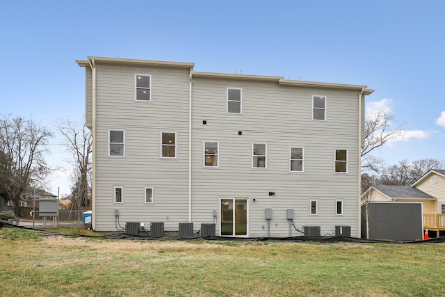 rear view of house with a yard and central air condition unit