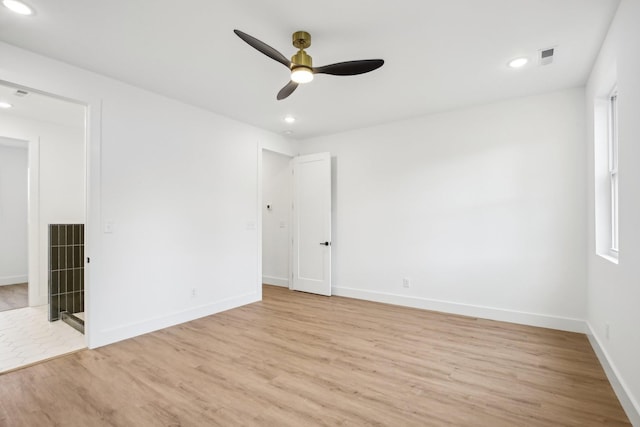 spare room with ceiling fan and light wood-type flooring