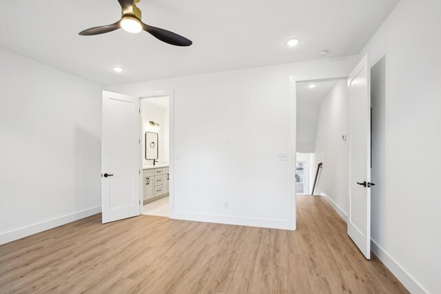 unfurnished bedroom with ensuite bathroom, ceiling fan, and light wood-type flooring