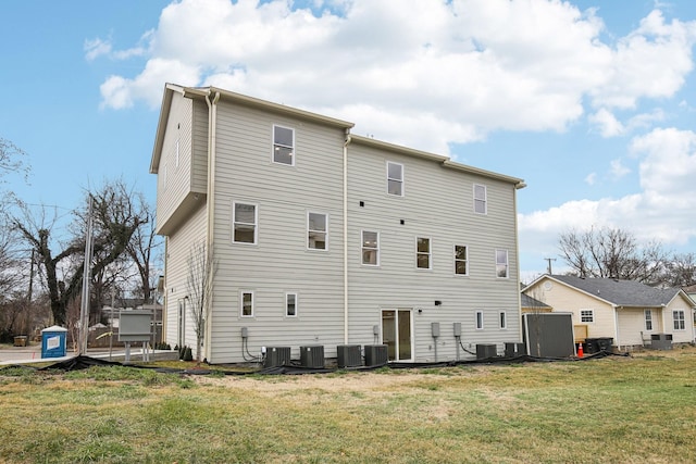 rear view of house with a yard and central air condition unit