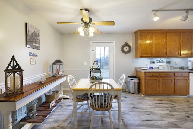 dining space with ceiling fan and light wood-type flooring