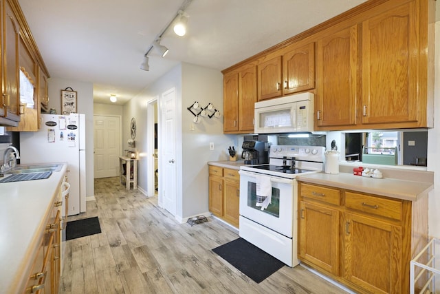 kitchen with sink, white appliances, and light hardwood / wood-style floors