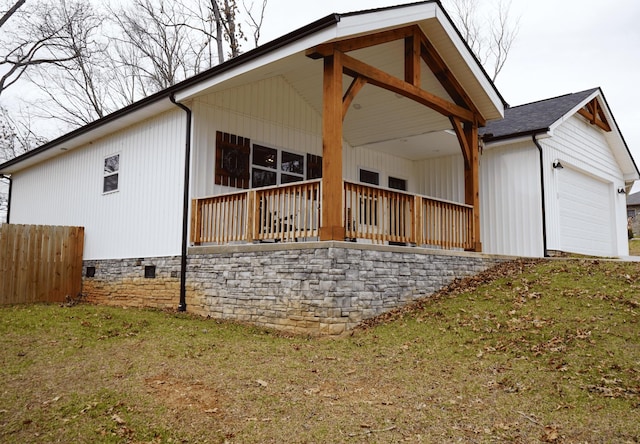 rear view of house featuring a garage and a yard