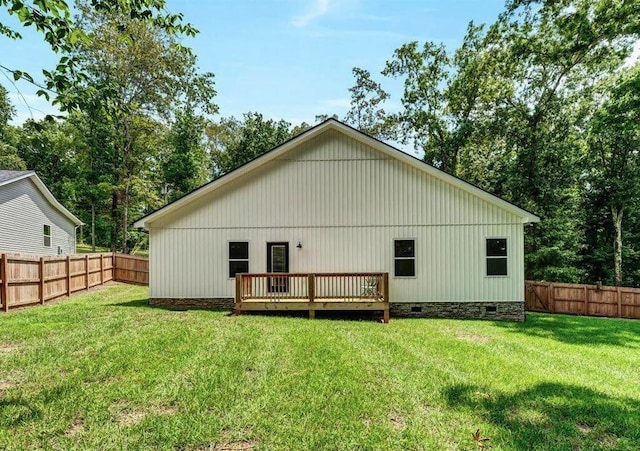 back of property featuring a yard and a deck