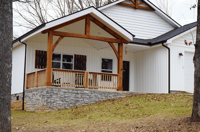 rear view of house with a garage and covered porch