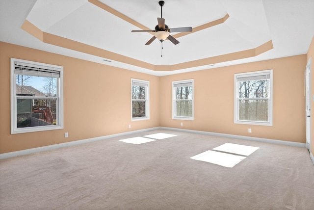 carpeted empty room with a tray ceiling and ceiling fan