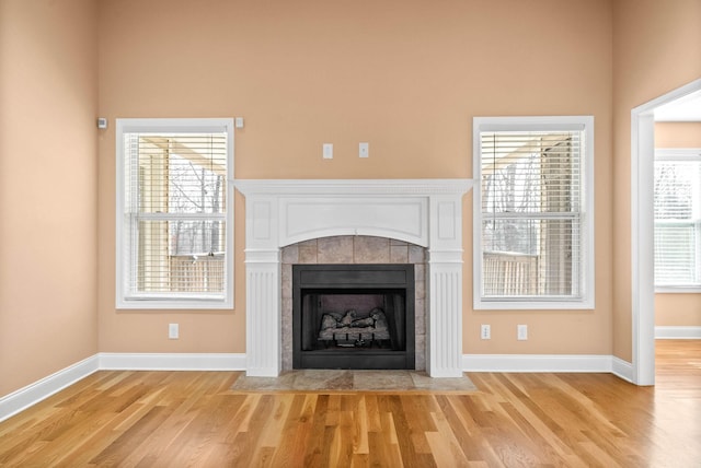 details featuring a tile fireplace and hardwood / wood-style floors